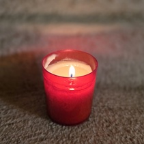 Kynttilän valo luo tunnelmaa illan hämärtyessä